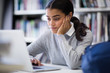 © ReeldealHD images - Student working on laptop in library