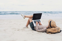 Young Woman Using Laptop Computer On A Beach. Freelance Work, Online Learning, Distance Work Concept