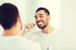 © Syda Productions - man with toothbrush cleaning teeth at bathroom