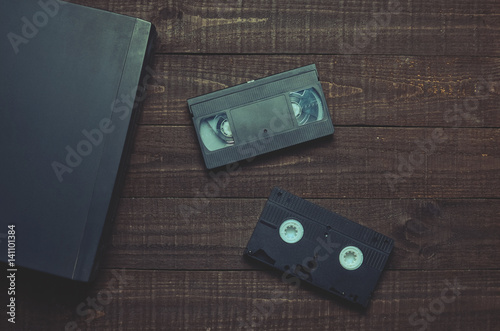 Fényképezés Video player and video cassettes on a wooden table.