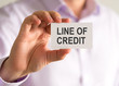 © stanciuc - Businessman holding a card with LINE OF CREDIT message
