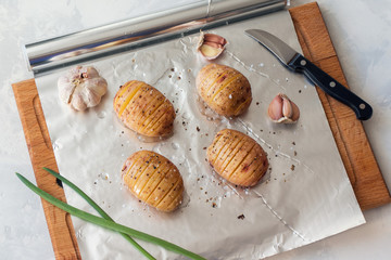 Canvas Print - sliced raw potatoes with spice on foil for baking