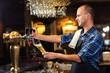 © bondvit - Bartender pouring the fresh beer in pub,barman hand at beer tap pouring a draught lager beer,beer from the tap,Filling glass with beer,fresh beer,pub.Bar.Restaurant.European bar.American bar.