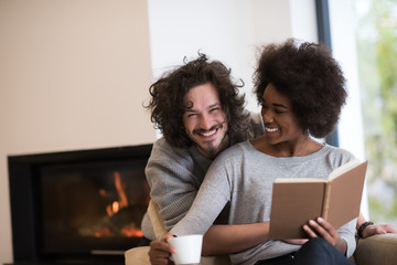 Wall Mural - multiethnic couple hugging in front of fireplace