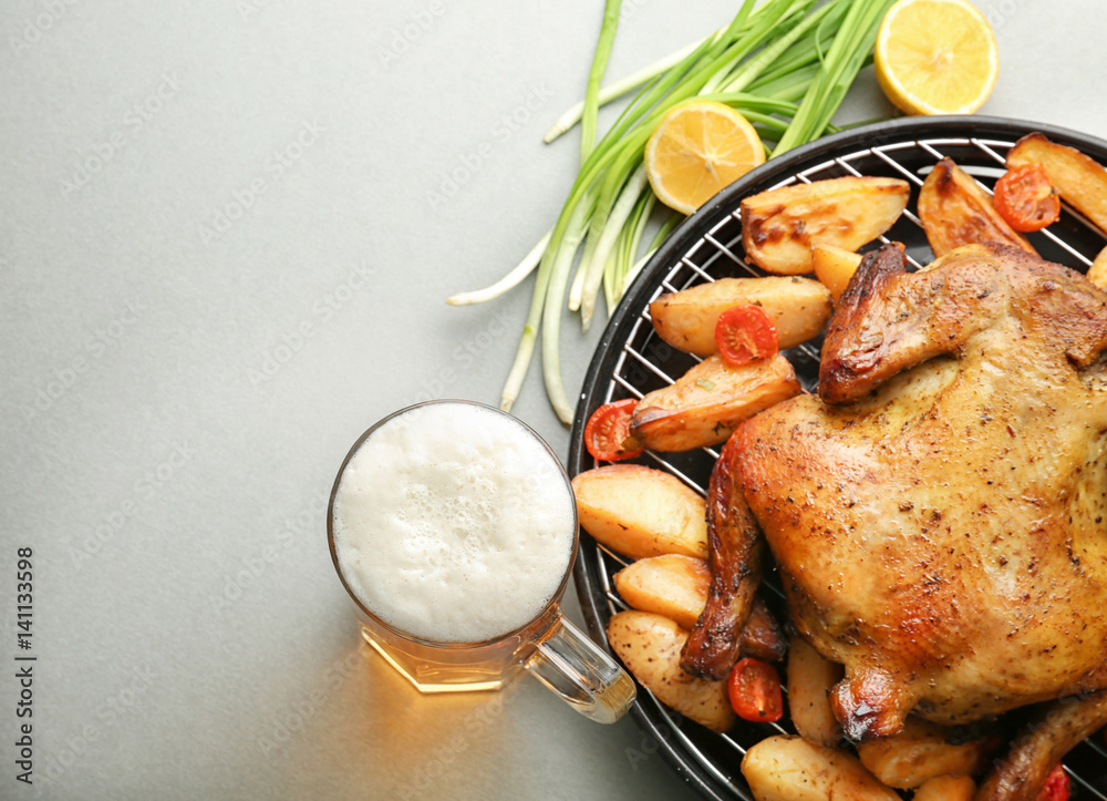 Grilled beer can chicken with vegetables on grey background