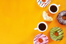 Coffee Break With Donuts Assorted. Pistachio, Chocolate, Vanilla, Strawberry Donuts And Two Cups Of Espresso Over Yellow Background. Copy Scape.