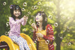 © Creativa Images - Mother and daughter playing in the playground