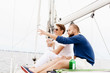 © Acronym - Happy friends sitting together on a deck of a yacht and drinking an alcoholic drink.
