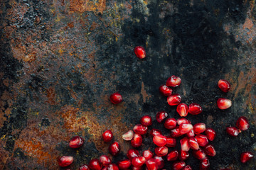 Wall Mural - Border made from pomegranate seeds over black rustic background.