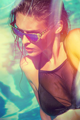 Wall Mural - attractive  girl in bikini and sunglasses in pool