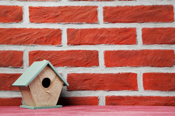 Wall Mural - Wooden nesting box on the brick wall background