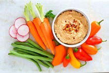 Hummus Dip With A Variety Of Fresh Vegetables, Above View On A White Marble Background