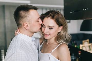 Beautiful and young couple flirting on the kitchen.