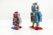 Pair of vintage tin toy robots isolated on white background