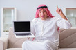 © Elnur - Arab businessman working sitting at couch