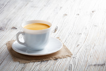 Poster - Coffee cup on a white wood background.