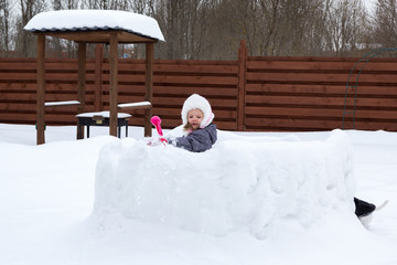 girl in snow fortress playing snowballs