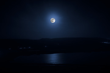 Wall Mural - Colorful night landscape with lake, mountains, full moon, blue sky Khojasan Lake, Baku, Azerbaijan. Panoramic photo. Nature background