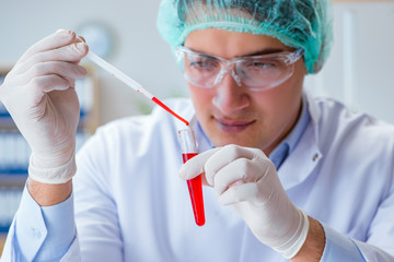 Young doctor working on blood test in lab hospital