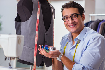 Young man tailor working on new clothing