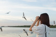 woman watching bird watching by the sea.