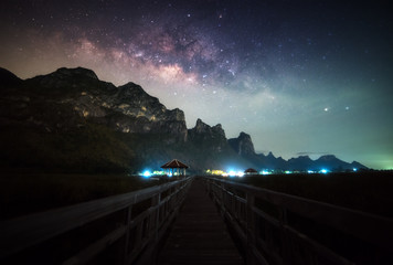 Wall Mural - clearly milky way with wooden path beautiful scene in thailand.