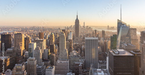 Plakat Nowy Jork. Panoramę centrum Manhattanu z oświetlonym Empire State Building i drapaczami chmur o zachodzie słońca.