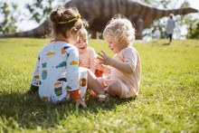 Young Girls Play To The Dinosaur Park