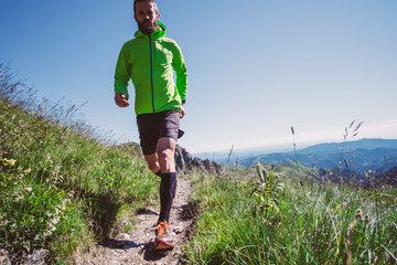 Wall Mural - man trail running on a mountain in summer
