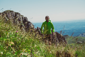 Wall Mural - man trail running on a mountain in summer
