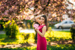 © Aleksandr - Beautiful girl posing to the photographer against the background of blooming pink trees. Spring. Sakura.