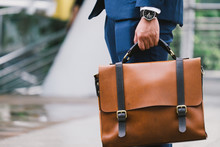 Closeup Of A Businessman Wear The Watch And Holding Leather Briefcase Going To Work With The Sunshine