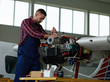 © pressmaster - Technical worker repairing motor of jet before flight season