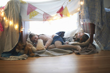 Two Sisters In Bedroom Den Lying Down With Soft Toys