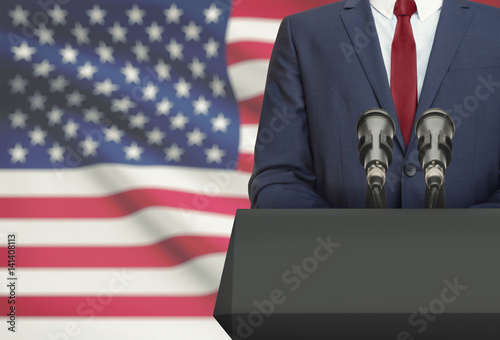 Fotografía Businessman or politician making speech from behind a pulpit with national flag