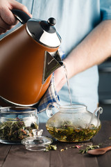 Wall Mural - man pouring herbal tea in the glass