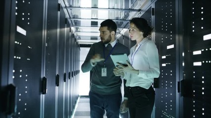 Wall Mural - Male and Female Server Technicians Working in Data Center. Running Rack Server Diagnostics. Woman Uses Tablet Computer. Shot on RED EPIC-W 8K Helium Cinema Camera.