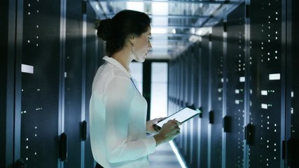 Wall Mural - Female IT Engineer Works on Tablet Computer in Data Center Full of Rows of Rack Servers. Shot on RED EPIC-W 8K Helium Cinema Camera.