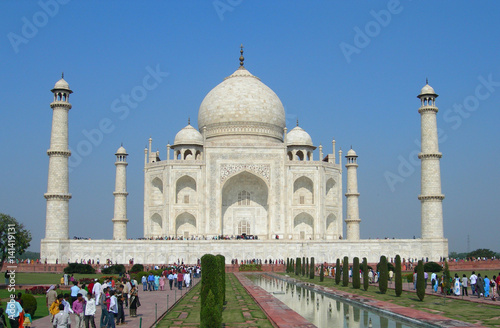 Fotografie, Obraz Iconic perspective of the Taj Mahal mausoleum in Agra, India, with the reflection pool and the main building dome framed by the minaret towers