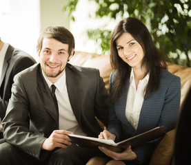 A group of successful entrepreneurs. Discussion of an important document in the office