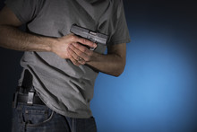 Man Drawing A Concealed Carry Pistol From A Holster