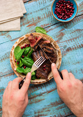 Sticker - Man eats a beef grilled steak with spinach and pomegranate