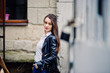 © AS Photo Family - Portrait of stylish young girl wear on leather jacket and ripped jeans at streets of city. Street fashion model style.