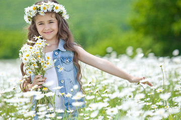 Beautiful little girl on nature with flowers 