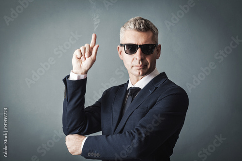 businessman holds his hand like a gun
