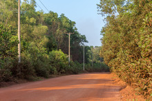 A Red Sand Dirt Road Cut Through A Dense Forest In Cambodia, South East Asia.