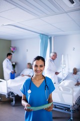 Wall Mural - Female doctor smiling while holding a file