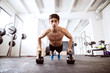 © Halfpoint - Young fit hispanic man in gym doing push ups on kettlebells