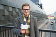 © vladdeep - A happy reporter leads a report on the camera on the street.