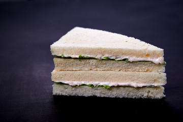 Wall Mural - fish white bread sandwiches with salad leaves on dark wooden background